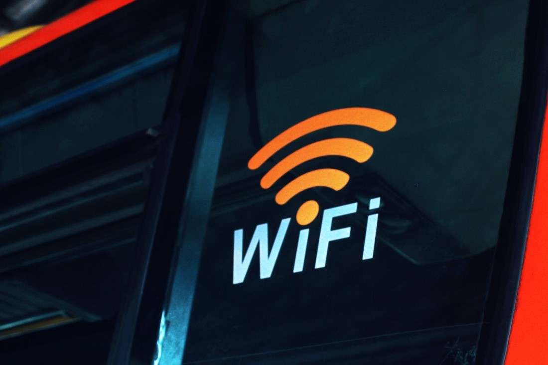 A close view of a logo printed on a window that reads “WiFi” with a connectivity symbol above it.